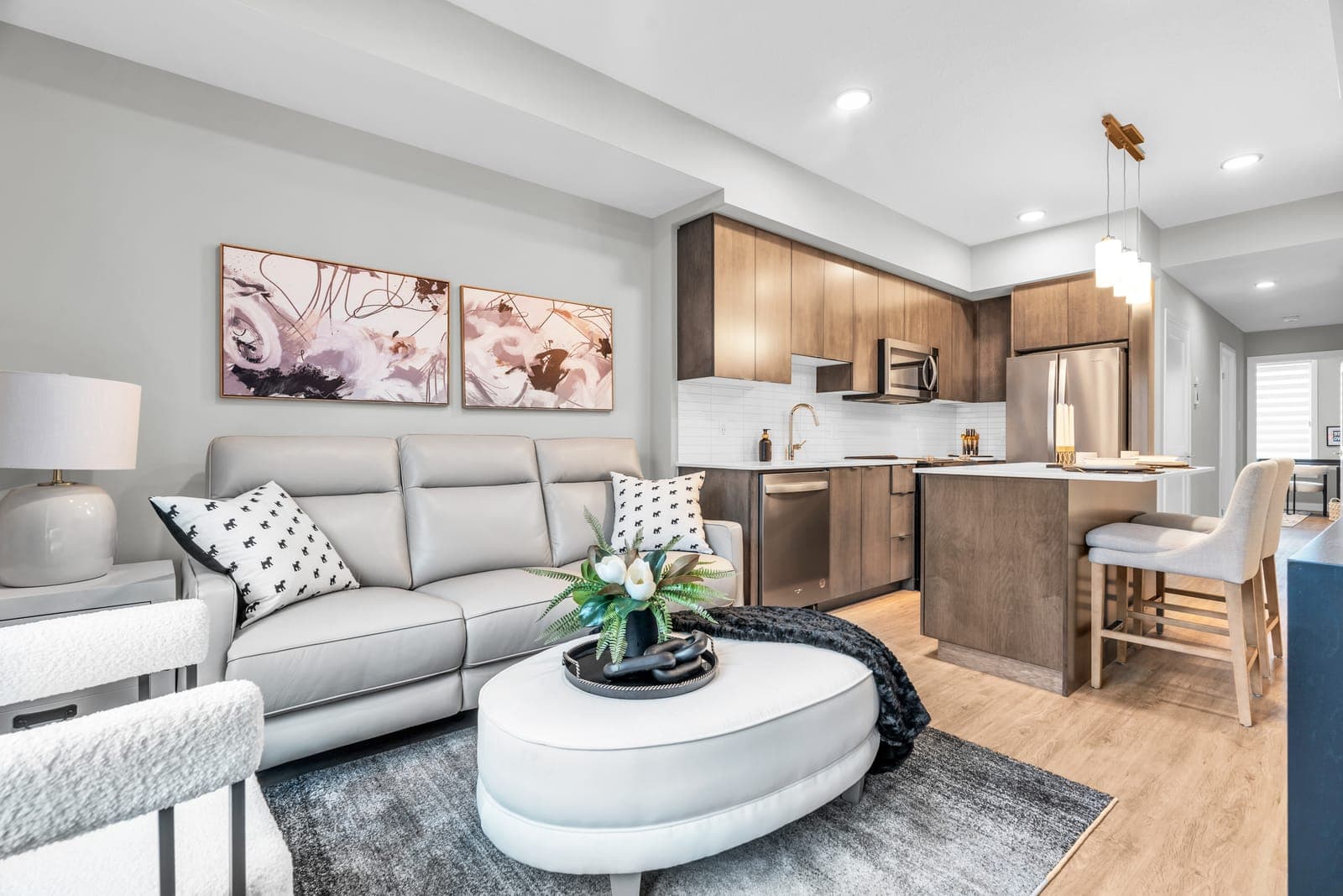 Living room of the Silver model home, open to a kitchen with wood-tone cabinets.